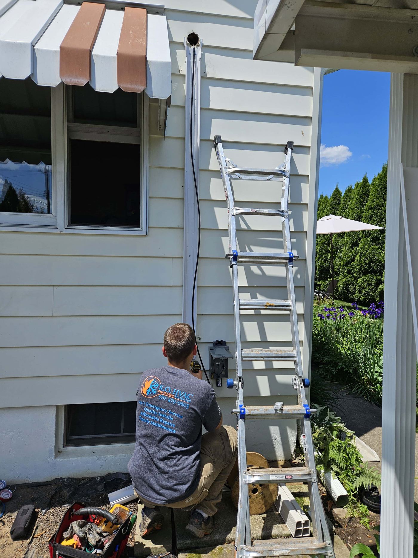 KO HVAC technician installing wire cover for ductless system in Wilkes Barre, PA.
