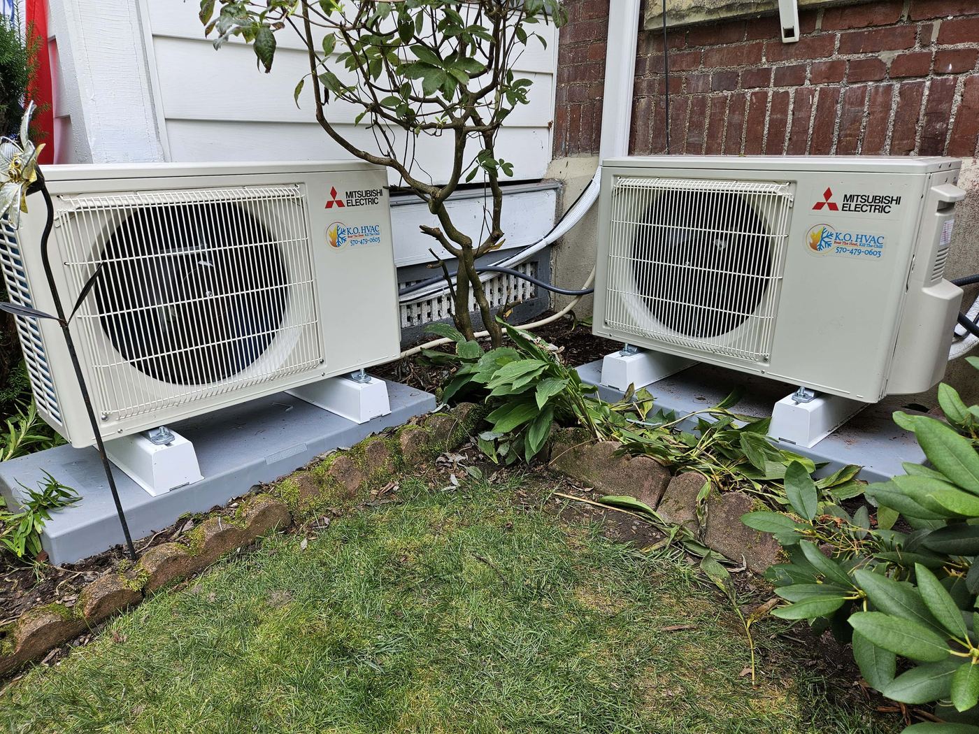 Two Mitsubishi air conditioners on concrete pads outside home in Kingston, PA.