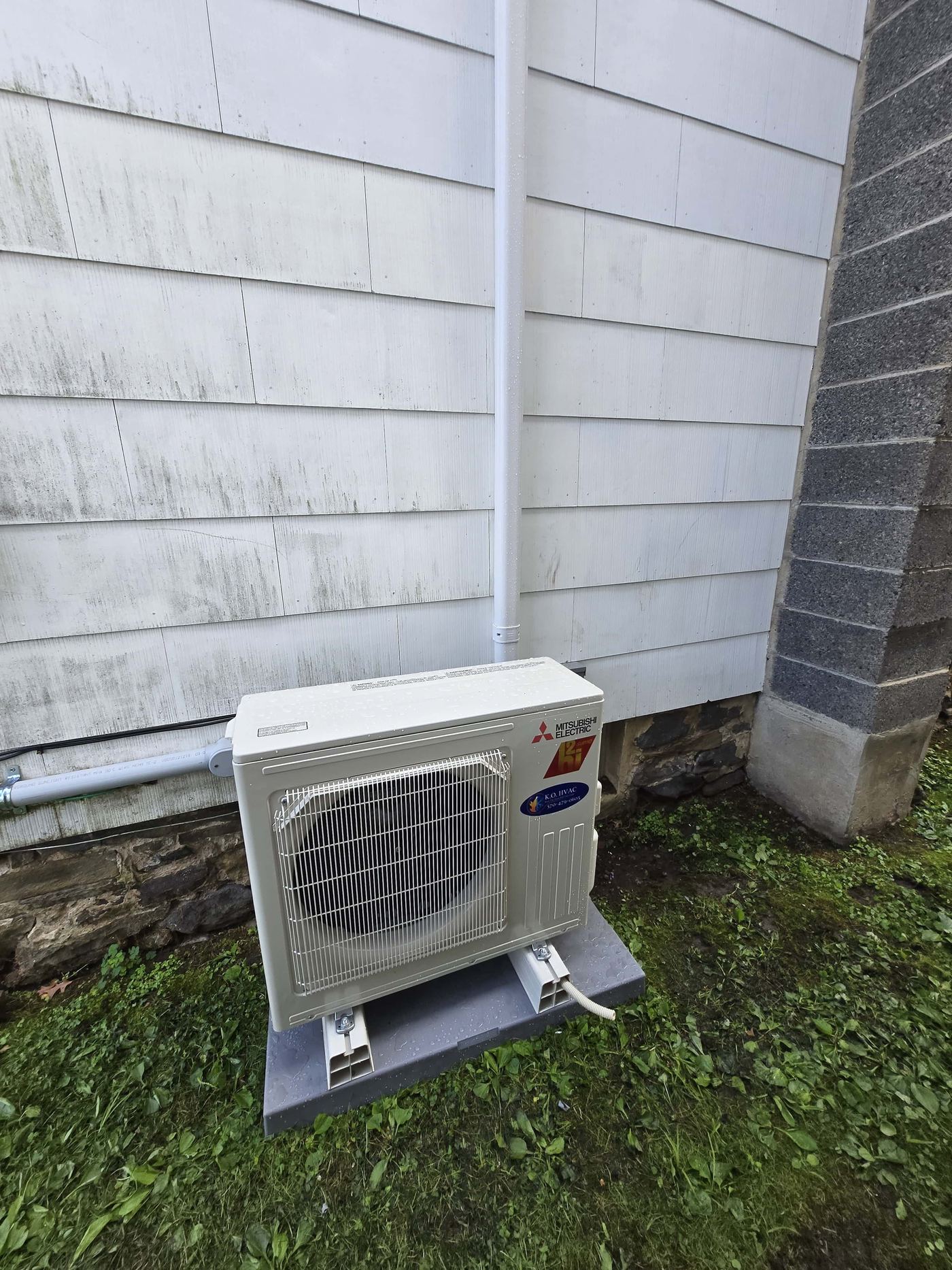Mitsubishi Electric ductless mini-split high efficiency condenser mounted on an residential exterior.
