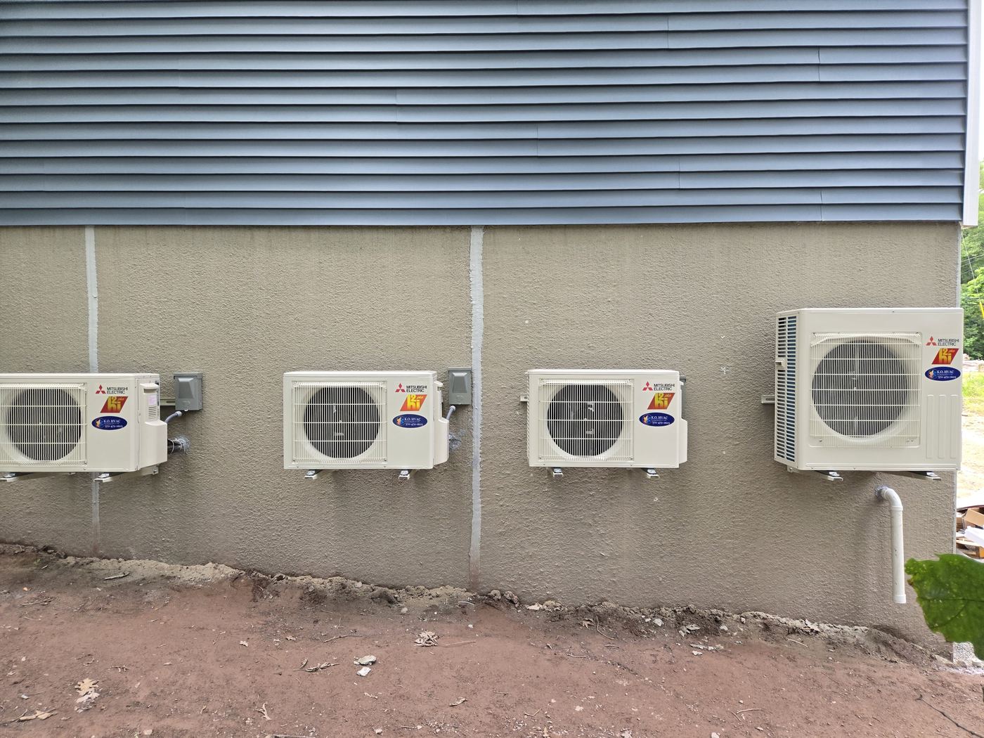 Mitsubishi Ductless High-Efficiency Condensers mounted on the outside of a house.