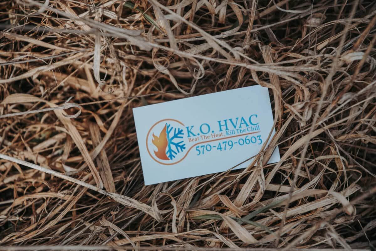 KO HVAC business card laying in straw.