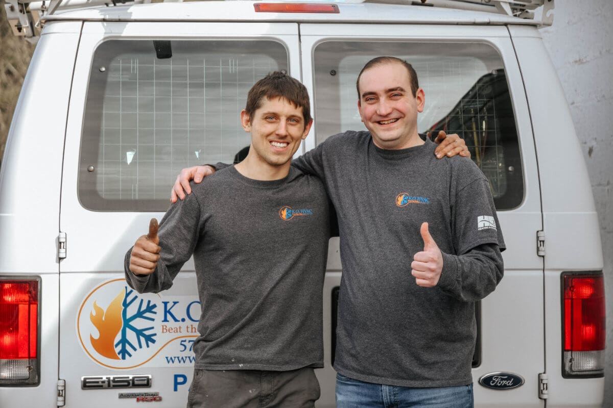 KO HVAC owners standing in front of company service vehicle at Kingston, PA, office.