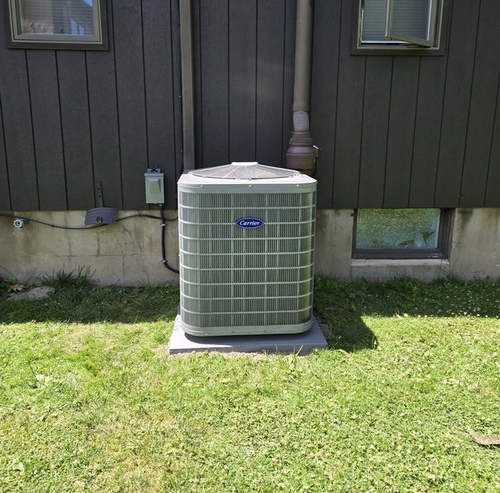 A new Carrier condenser installed beside a home