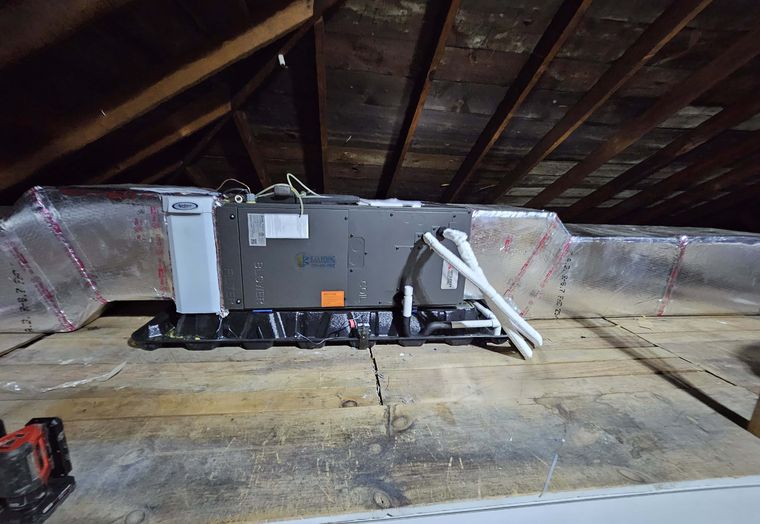 A horizontal Mitsubishi air handler in an attic with flex duct and a condensate line