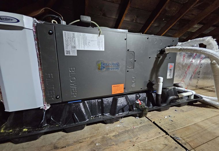 An attic air handler with the KO HVAC label on its cabinet