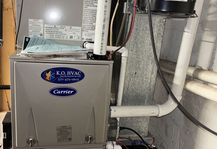 A Carrier furnace with a KO HVAC plate in a utility room