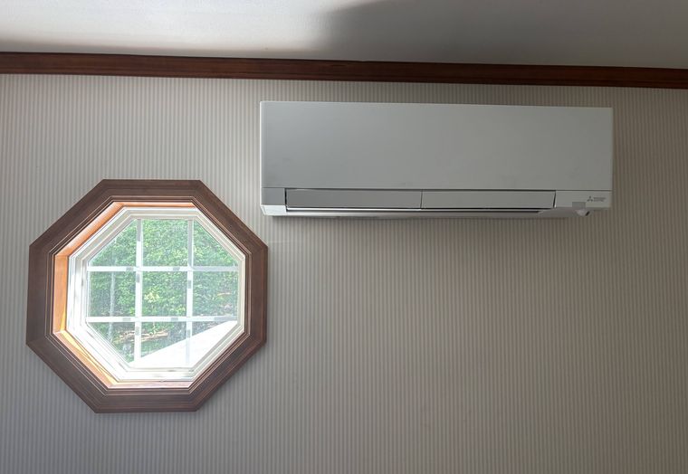 A Mitsubishi wall unit above an octagonal window
