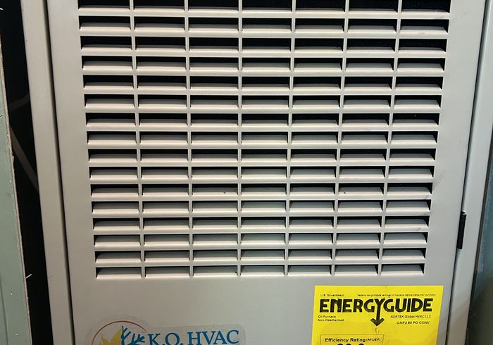 A furnace panel with a KO HVAC sticker and its EnergyGuide label