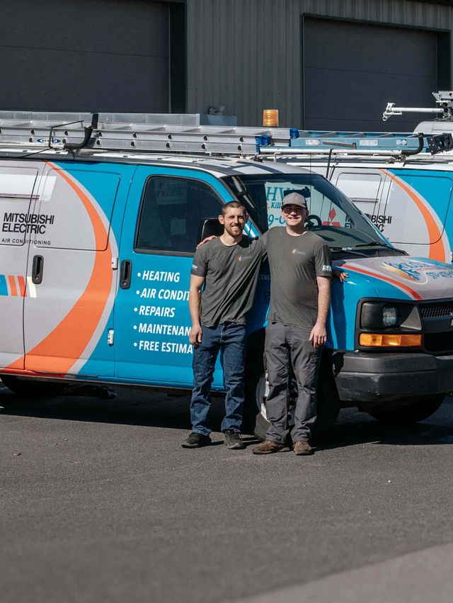 The KO HVAC crew standing with their wrapped vans outside the Kingston shop