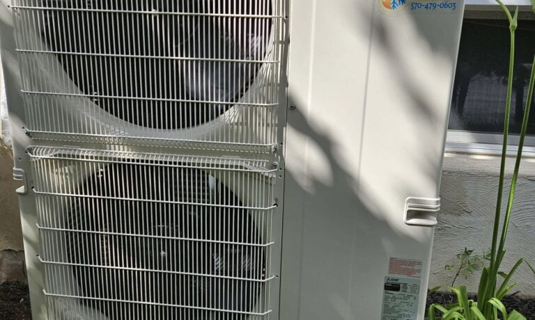 A two-fan Mitsubishi heat pump outdoor unit with a KO HVAC label
